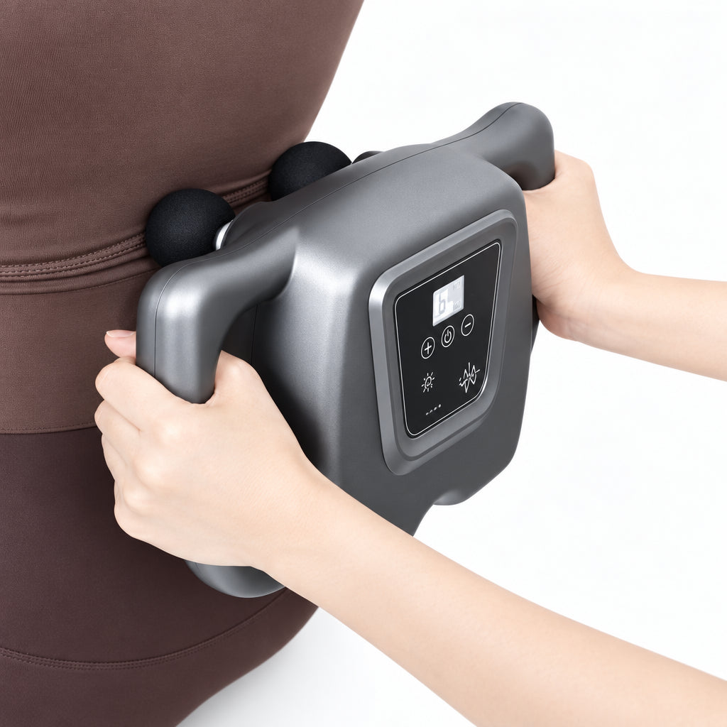 Person using a handheld massage device on their arm with a neutral background