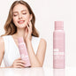 Woman holding a pink bottle of 'Hair Identifier Spray' with a plain background